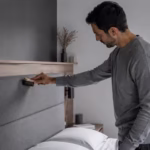 Hombre quitando el polvo de un cabecero tapizado en un dormitorio moderno